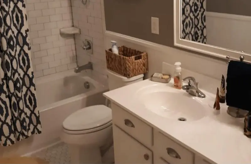 Bathroom with a subway tile tub surround and white vanity