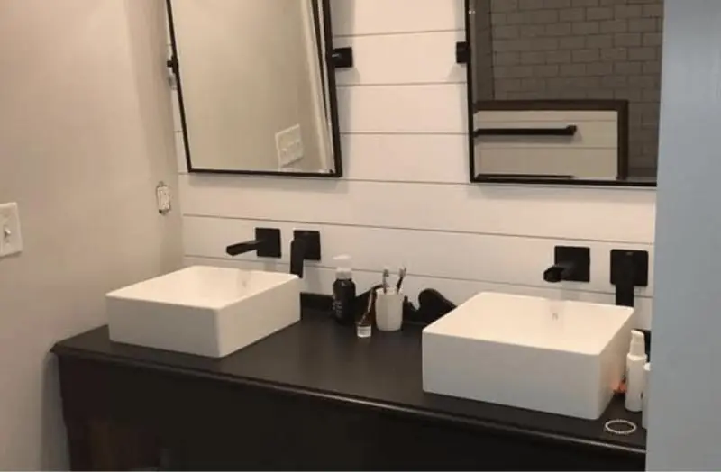 Bathroom vanity with two vessel sinks and shiplap wall