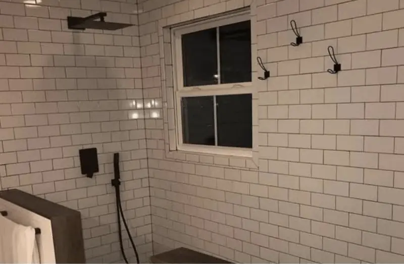 Walk-in shower with white subway tile and black fixtures